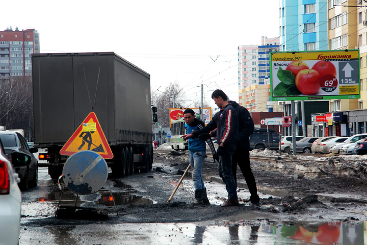 Весенние ямы на дорогах Новосибирска оставляют машины без колес (фоторепортаж)